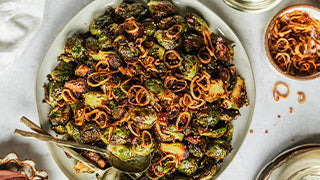 Charred Brussels Sprouts with Miso-Caramel Glaze, Black Garlic Soil, and Crispy Shallot Nest