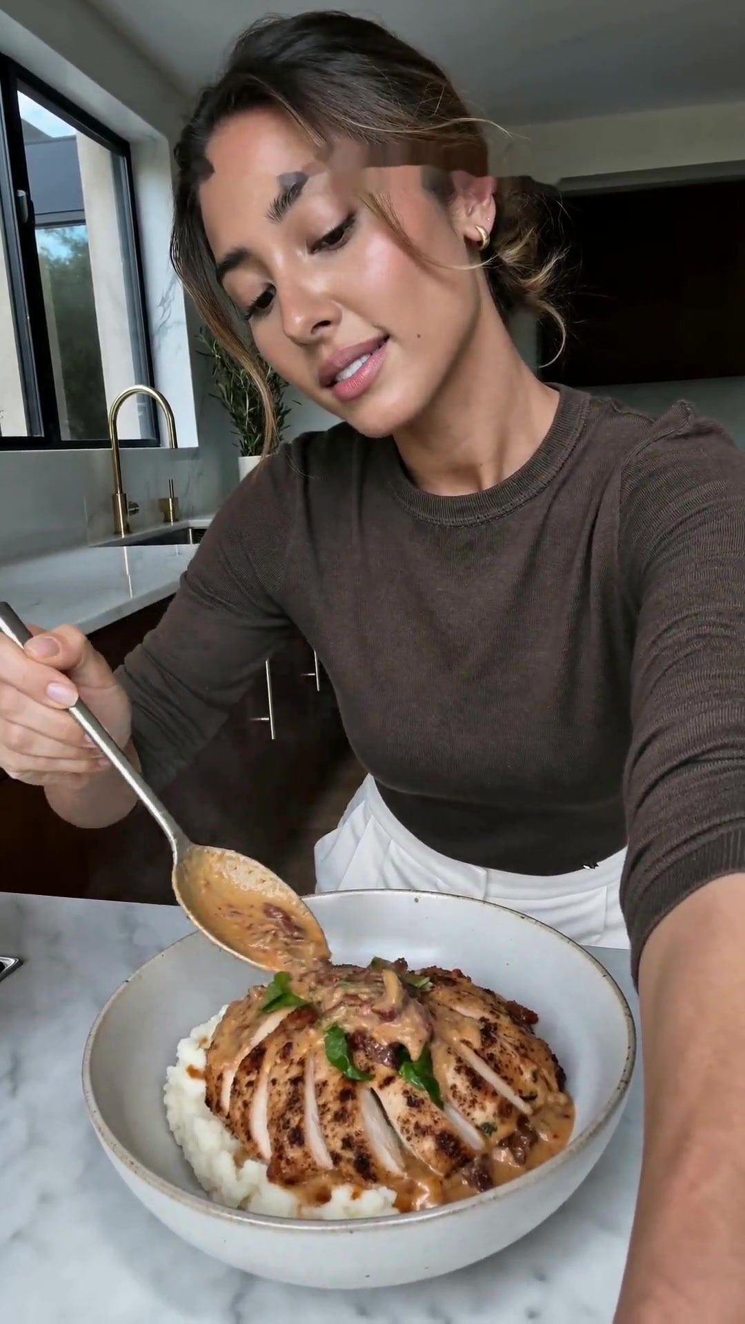 Dairy free Marry Me Chicken sliced over mashed potato with creamy sun dried tomato sauce and fresh basil